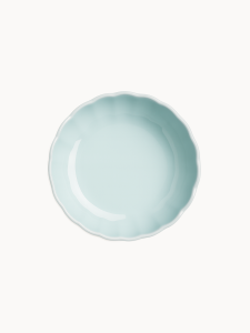 Zdjęcie z góry na pastelową jasnoniebieską ceramiczną paterę, na jednolitym białym tle.